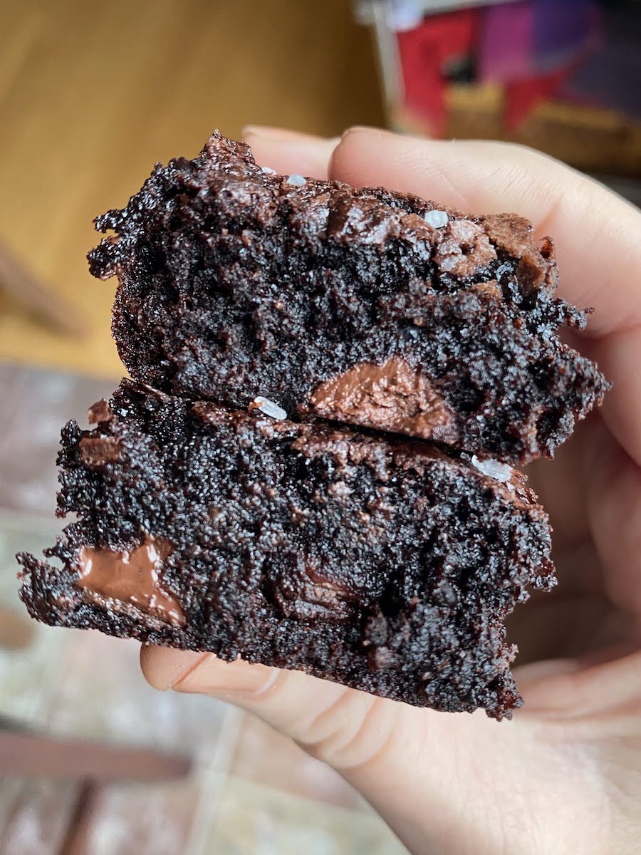 two dark chocolate brownies in hand