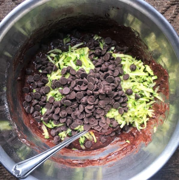 Mixing bowl with chocolate batter, grated zucchini, and chocolate chips
