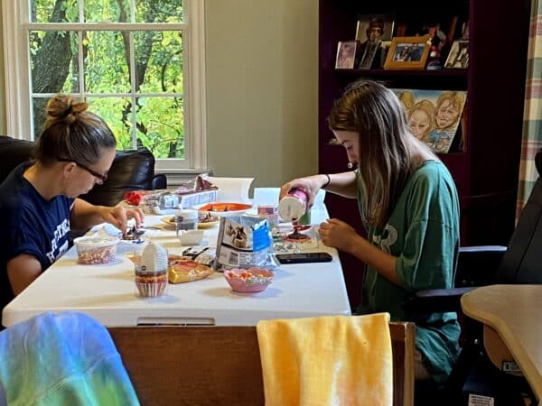 Author and daughter sitting at table decorating no bake Halloween treats.