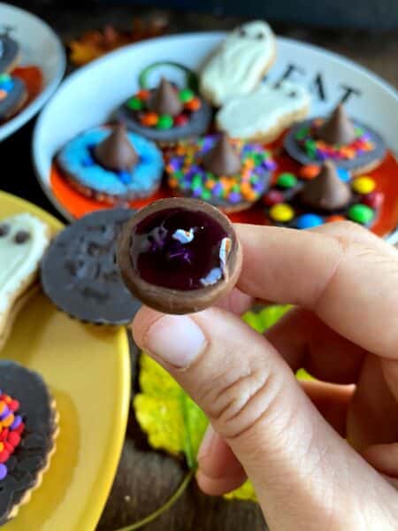 Bottom of chocolate kiss covered in gel frosting, with many decorated cookies spread out below it.