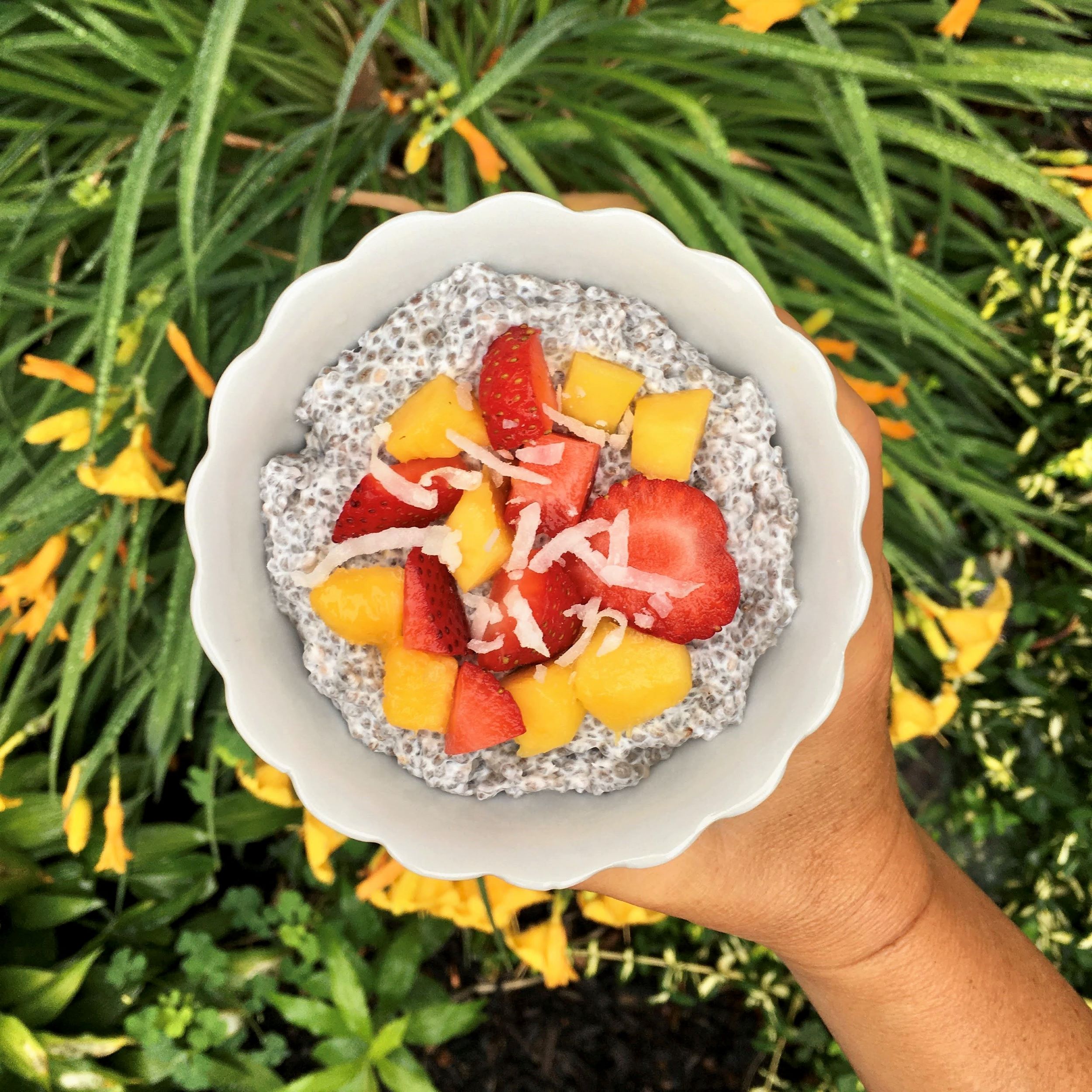 Coconut chia pudding topped with mango, strawberry and coconut flakes